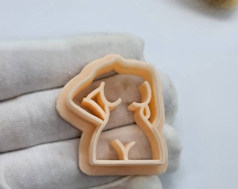 May include: A light peach-colored plastic cookie cutter shaped like a human figure.