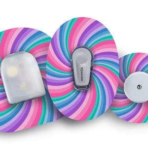 Puede incluir: Tres parches redondos, coloridos y adhesivos con un patrón de arcoíris en espiral. Los parches están diseñados para un dispositivo médico. Un parche tiene un pequeño sensor redondo blanco, otro tiene un pequeño sensor rectangular blanco y el tercero tiene un pequeño transmisor rectangular blanco con el texto "dexcom G6".