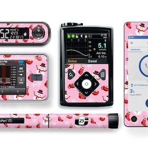 Könnte beinhalten: Ein Set mit rosa-weißen bedruckten Skins für ein Diabetes-Überwachungsgerät, eine Insulinpumpe und einen Stift. Das Muster zeigt Schneemänner, Schneeflocken und rote Strümpfe. Der Bildschirm des Monitors zeigt einen Blutzuckerwert von 5,1 mmol/L. Der Bildschirm der Pumpe zeigt einen Blutzuckerwert von 88 mg/dL. Der Stift ist mit "NovoPen" beschriftet.