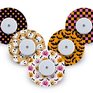 May include: Six circular decorative stickers with white centres. The stickers feature Halloween-themed patterns, including polka dots, ghosts, bats, pumpkins, and checkered designs in orange, black, pink, and white.