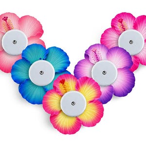 Può includere: Cinque cerotti adesivi circolari per sensori medici, ognuno con un vivace design a fiore di ibisco. I fiori sono rosa, blu, viola e con sfumature giallo-rosa, con un centro bianco circolare e una piccola icona nera nel mezzo.