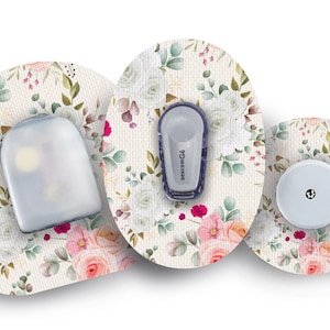 May include: Three round medical patches with a floral design. The patches are white with pink and green flowers. The center patch has a small, round, white sensor with a black dot in the center. The left patch has a clear, rectangular sensor with a small, white light. The right patch has a small, rectangular, purple sensor with the text "dexcom G6" printed on it.