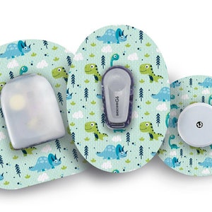 Puede incluir: Tres parches médicos redondos con un patrón de dinosaurios. Los parches son de color azul claro con dinosaurios verdes y azules, nubes blancas y árboles verdes. Los parches están diseñados para un dispositivo médico.