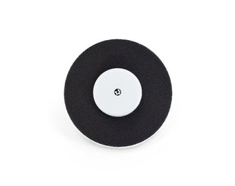 May include: A black round adhesive electrode pad with a white center circle and a small black dot in the center.