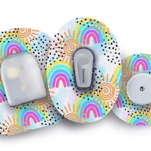 Peut inclure: Trois patchs médicaux ronds et colorés avec un motif arc-en-ciel, soleil et nuage. Les patchs sont conçus pour être portés sur la peau. Un patch a un petit capteur blanc, un autre a une pompe à insuline blanche et le troisième a une canule blanche.