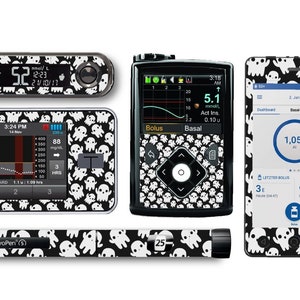 Può includere: Un set di quattro dispositivi medici in bianco e nero con un motivo a forma di fantasma. I dispositivi includono un misuratore di glucosio, un monitor continuo di glucosio, una pompa per insulina e una penna per insulina. I dispositivi sono tutti ricoperti da un motivo a forma di fantasma in bianco e nero.