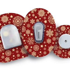 May include: Three round, red, adhesive patches with a snowflake and star pattern. The patches are designed to cover medical devices. One patch has a clear, plastic cover, another has a small, white, round device with a black dot in the centre, and the third has a blue and white medical device with the text "dexcom G6".