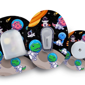 May include: Three round, colourful adhesive patches with a space theme. The patches feature cartoon dinosaurs wearing astronaut suits and riding rockets. The patches are designed for use with a medical device.