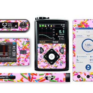 Puede incluir: Un conjunto de cuatro pegatinas con estampado rosa y blanco para un monitor de diabetes, una bomba de insulina y una pluma de insulina. El patrón presenta coloridos espolvoreados sobre un fondo rosa. Las pegatinas incluyen el texto "NovoPen (5)" y "25".