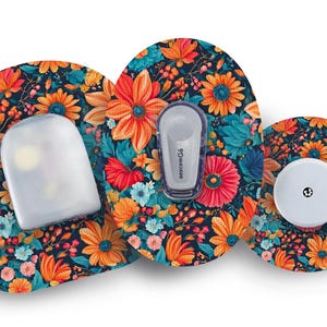 Pode incluir: Três adesivos redondos com um padrão floral em tons de laranja, azul e verde. O adesivo central tem um círculo branco com um pequeno ponto preto. O adesivo da esquerda tem uma cobertura de plástico transparente com um pequeno círculo branco no centro. O adesivo da direita tem um pequeno círculo branco com um ponto preto no centro. O texto "Dexcom G6" está impresso no adesivo da direita.