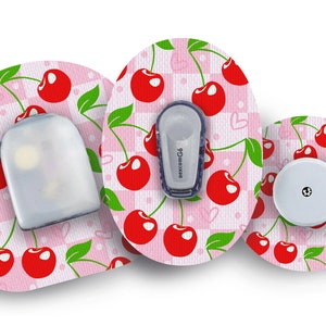 May include: Three round adhesive patches with a pink and white checkered background and a pattern of red cherries. The center patch has a clear plastic cover with a small gray device that says "dexcom G6".
