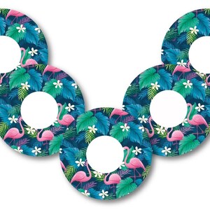 Pode incluir: Cinco adesivos redondos com tema tropical. Cada adesivo apresenta um flamingo rosa, folhas de palmeira verdes e flores brancas sobre um fundo azul escuro. O centro de cada adesivo é um círculo branco.
