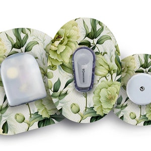 May include: Three round, white, adhesive patches with a floral pattern. The centre patch has a small, white, round sensor with a black dot in the centre. The left patch has a clear, rectangular sensor with the text "dexcom G6" printed on it. The right patch has a clear, rectangular sensor with a white cap.