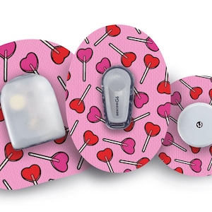 May include: Pink adhesive patches patterned with heart-shaped lollipops. The patches hold medical devices, including a white sensor and a grey transmitter. The design is repeated across the patches, creating a playful and colourful aesthetic.