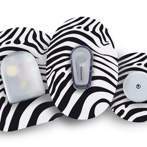 Puede incluir: Tres parches adhesivos con estampado de cebra blanco y negro con un pequeño sensor redondo transparente, un sensor ovalado transparente más grande y un pequeño sensor ovalado gris con el texto "dexcom G6" impreso en él.