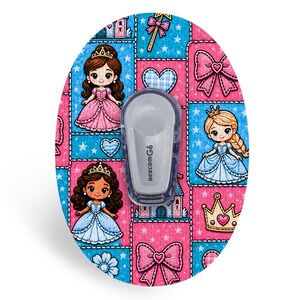 K&ouml;nnte beinhalten: Ein ovales Klebepflaster mit einem sich wiederholenden Muster aus Cartoon-Prinzessinnen, Kronen, Herzen und Schleifen in Rosa- und Blaut&ouml;nen. Ein grauer medizinischer Dexcom G6-Sender ist mittig auf dem Pflaster platziert, das ein gitterartiges Design aufweist.