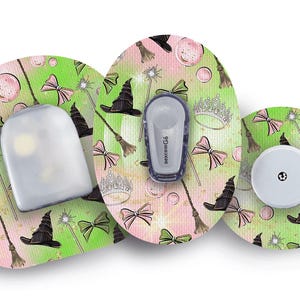 Puede incluir: Conjunto de dispositivos médicos con un diseño temático de brujas. Los dispositivos presentan sombreros de bruja, lazos, varitas y coronas sobre un fondo rosa y verde. El conjunto incluye un sensor, un transmisor y un receptor.