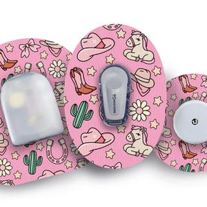 Peut inclure: Trois patchs médicaux roses et blancs à motifs sur le thème du cow-boy. Les patchs présentent des images de chevaux, de bottes, de chapeaux, de cactus et d'étoiles. Un patch a un réservoir transparent, un autre a un capteur blanc et le dernier a un bouton blanc.