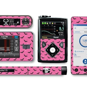 Könnte beinhalten: Ein Set mit rosa und schwarzen bedruckten Skins für ein Blutzuckermessgerät, eine Insulinpumpe und einen Insulinpen. Das Muster zeigt Fledermäuse und weiße Punkte auf einem rosa Hintergrund.