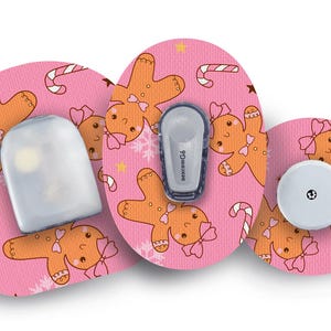 May include: Pink medical device accessories with a gingerbread man pattern, candy canes, and stars. The set includes a sensor, transmitter, and a receiver. The transmitter has the text "Dexcom G6".