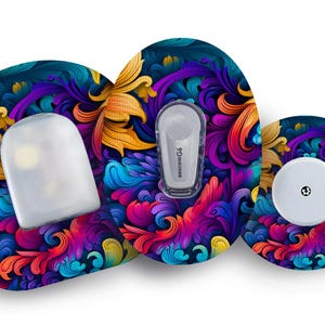 Op de afbeelding: Drie kleurrijke, ronde, zelfklevende pleisters met een bloemenmotief. De pleisters zijn ontworpen om medische apparaten te bedekken. De pleisters hebben een verscheidenheid aan kleuren, waaronder blauw, paars, geel en oranje.