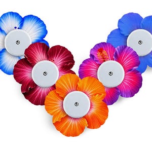 May include: Five circular white medical sensor patches, each centred on a vibrant hibiscus flower sticker. The flowers feature petals in shades of blue, deep red, bright orange, magenta, and a lighter blue, arranged in a V-shaped formation.