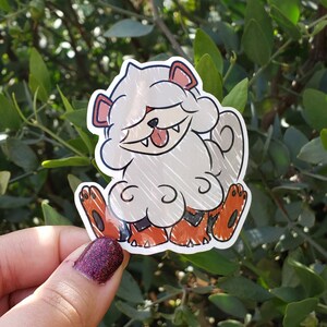 May include: A white and orange cartoon sticker of a fluffy dog with a big smile and a tongue sticking out. The dog is sitting on its hind legs with its front paws in the air.