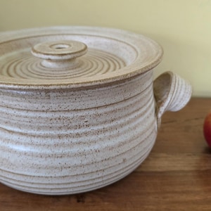 May include: A set of three ceramic mugs with a speckled, matte finish in cream, light grey, and dark grey. Each mug has a simple, minimalist design, suitable for coffee or tea.