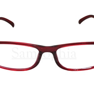 Può includere: Un paio di occhiali da lettura in plastica rossa con montatura rettangolare.