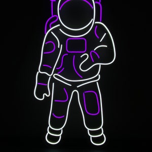 May include: Purple and white neon sign of an astronaut in a space suit. The sign says "COLOR SET 5" at the top.