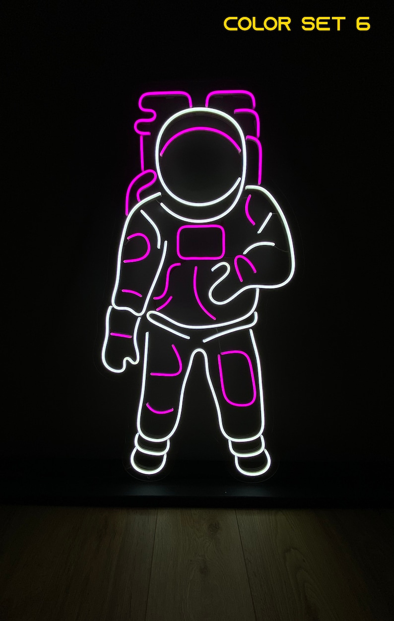 May include: Neon sign of an astronaut in white with pink outlines. The sign says "COLOR SET 6" at the top.