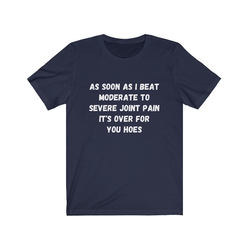 May include: Navy blue t-shirt with white text that reads "AS SOON AS I BEAT MODERATE TO SEVERE JOINT PAIN IT'S OVER FOR YOU HOES"