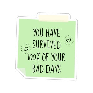 May include: Green sticky note with the text "You have survived 100% of your bad days" with two small hearts on either side of the text.