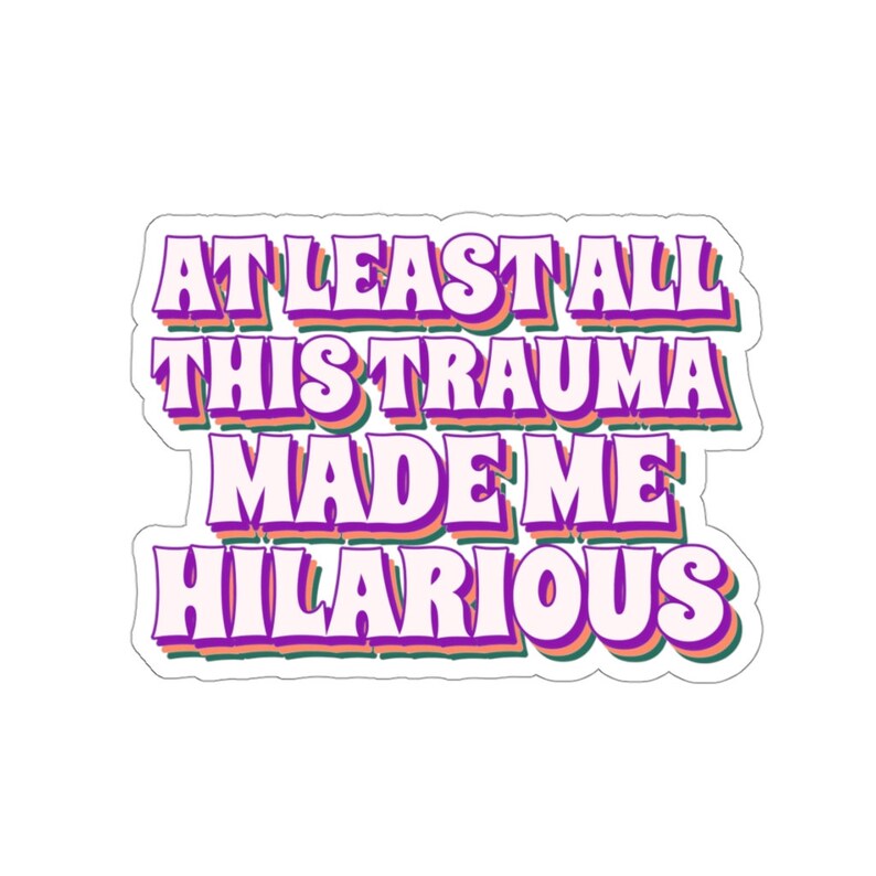 May include: A sticker with the text "At least all this trauma made me hilarious" in a retro font with pink, green, and orange outlines.