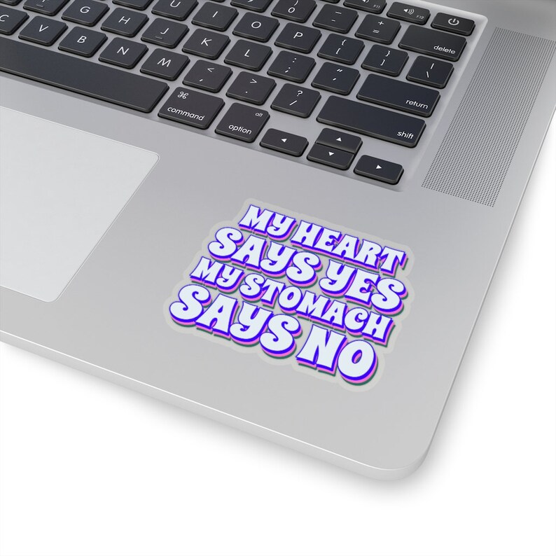 May include: A sticker with the text "My heart says yes, my stomach says no" in a retro, colorful font. The text is white with a purple outline.