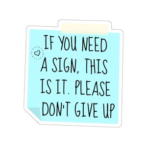 May include: A blue sticky note with the text "IF YOU NEED A SIGN, THIS IS IT. PLEASE DON'T GIVE UP" and a small heart symbol.