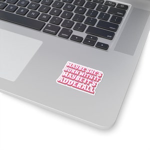 May include: A pink and white sticker with the text "Maybe she's born with it, maybe it's Adderall" in a retro font style.