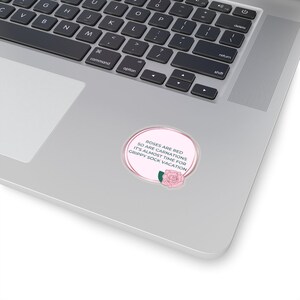 May include: A pink circle sticker with a white outline and a pink rose with green leaves. The text on the sticker reads "Roses are red, so are carnations, it's almost time for grippy sock vacation."