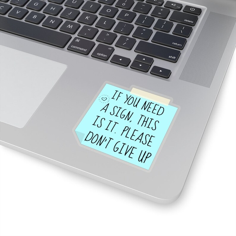 May include: A blue sticky note with the text "If you need a sign, this is it. Please don't give up."  The note has a small heart drawn in the top left corner.