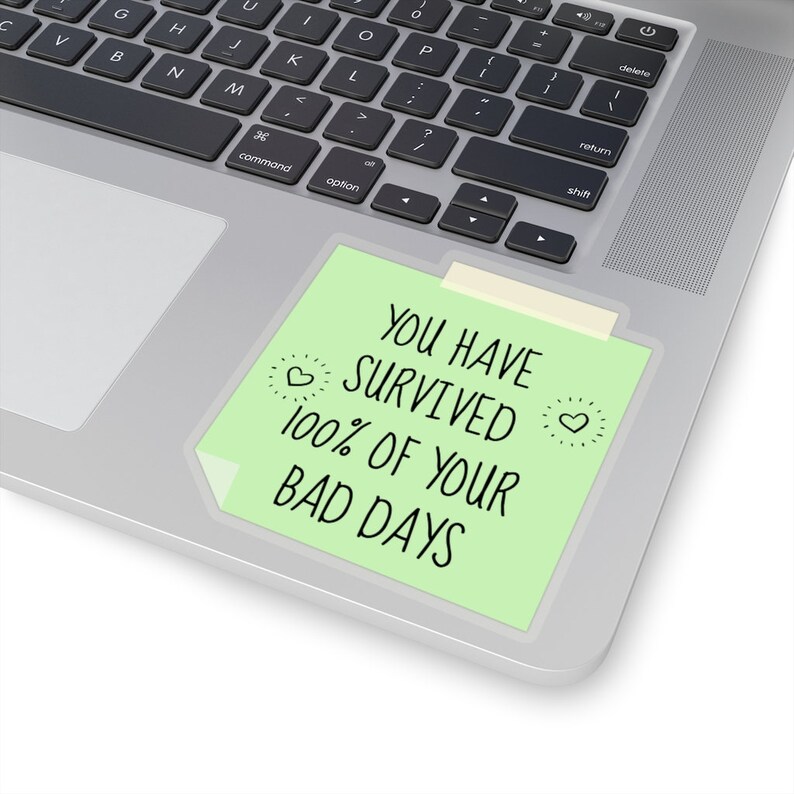 May include: A green sticky note with the text "You have survived 100% of your bad days" on a silver laptop.