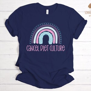 May include: A navy blue t-shirt featuring a rainbow graphic and the text "cancel diet culture".