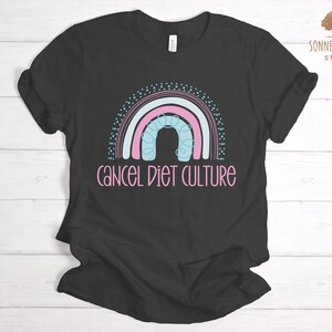 May include: Black t-shirt featuring a rainbow design and the text "cancel diet culture" in pink.