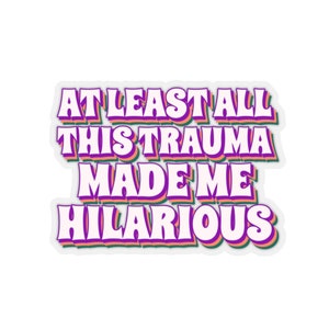 May include: A sticker with a white background and a purple, green, and orange outline. The text on the sticker reads "At least all this trauma made me hilarious."