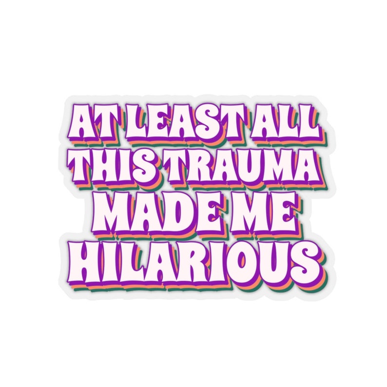 May include: A sticker with a white background and a purple, green, and orange outline. The text on the sticker reads "At least all this trauma made me hilarious."