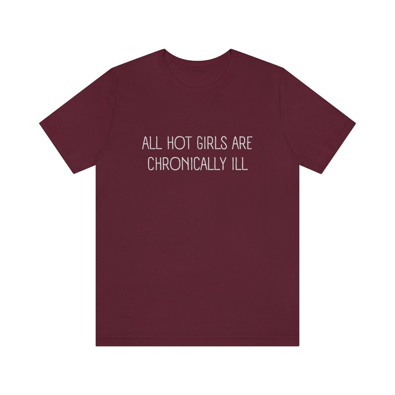 May include: Burgundy t-shirt with the text "ALL HOT GIRLS ARE CHRONICALLY ILL" printed in white.