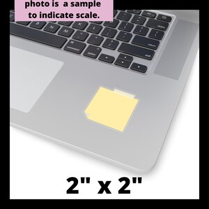 May include: A yellow sticky note with a folder icon on a silver laptop keyboard. The note is 2 inches by 2 inches.