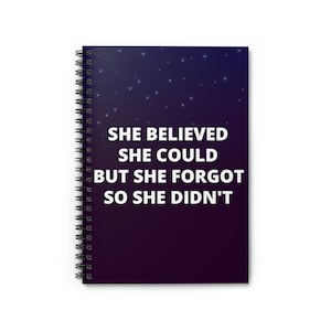 May include: A dark purple and black spiral notebook with a starry night sky background. The text "She believed she could but she forgot so she didn't" is printed in white on the front cover.