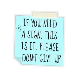 May include: A blue sticky note with the text "IF YOU NEED A SIGN, THIS IS IT. PLEASE DON'T GIVE UP" and a small heart symbol.