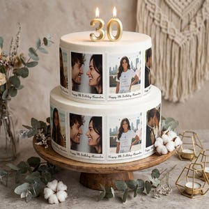 May include: A two-tier white cake decorated with edible photo prints in a square frame style. The photos show a person and a couple. The text "Happy 30th Birthday Alexandra" is printed below each photo. Two gold number candles, 3 and 0, sit on top.