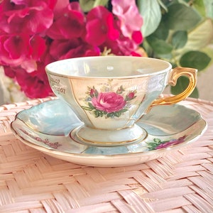 Ensemble de tasses et soucoupes roses sur pieds bleu pastel et lustre nacré. Mitasse vintage avec bordures et détails dorés